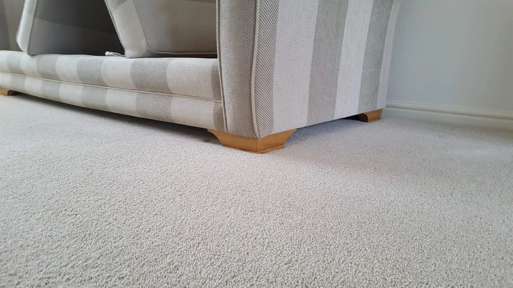 Clean beige carpet in a lounge with sofa